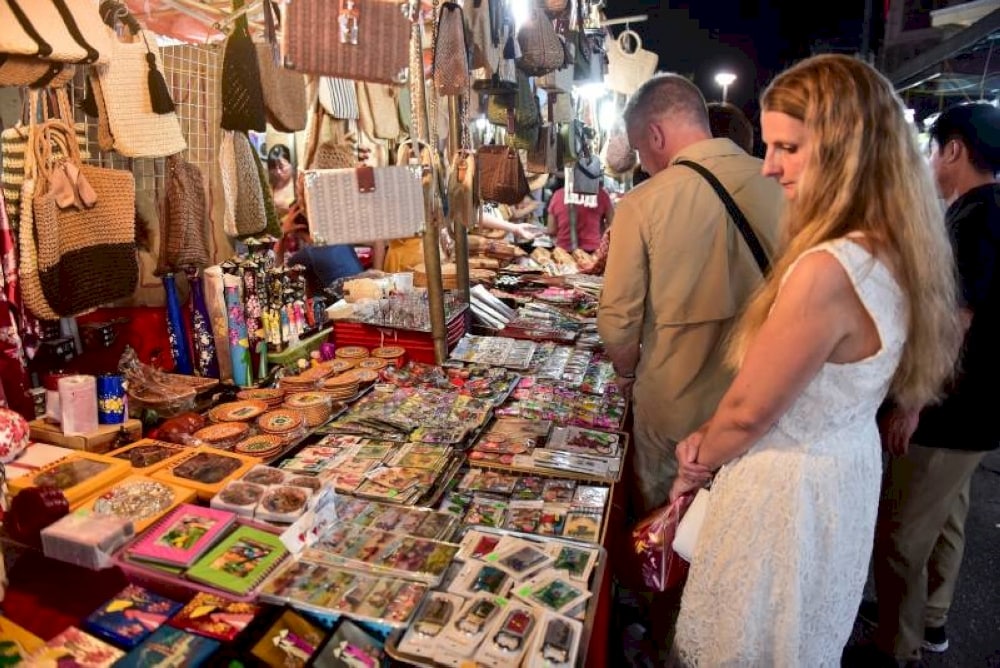 Western tourists enjoy shopping at the night market in Hanoi